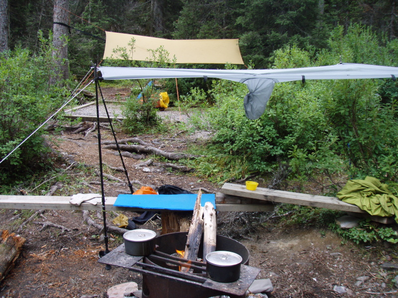 Numa Campground. Everything in the picture, except the second pot, came from my 30 litre pack - my hammock, tarp, and poncho rigged on poles, and the fire I lit with stream driftwood. Interestingly, we had many visitors for discussion and dinner, since those packing 90 litre loads didn't seem to have tarps or fire :)